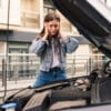 young worried girl is using phone explain mechanic problem with car that she has
