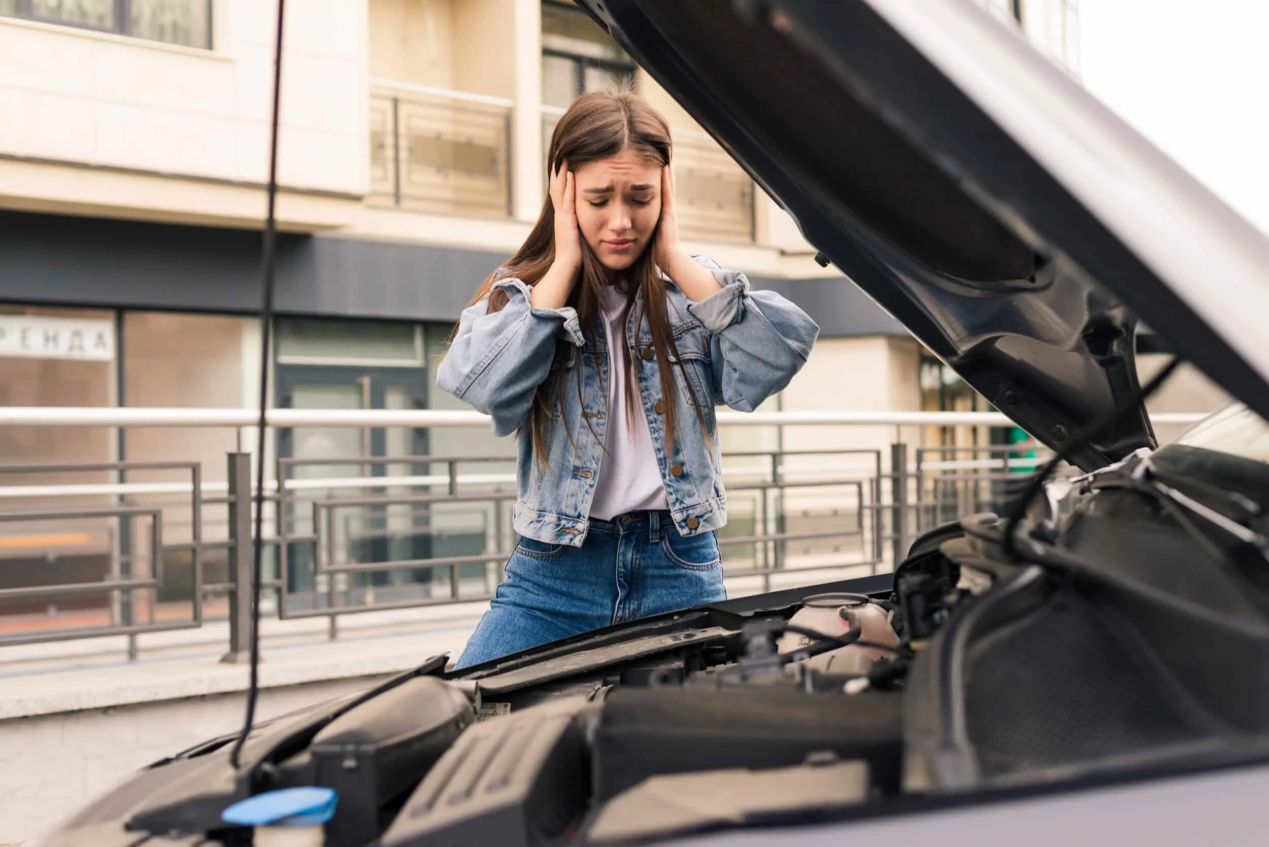 young worried girl is using phone explain mechanic problem with car that she has scaled 1