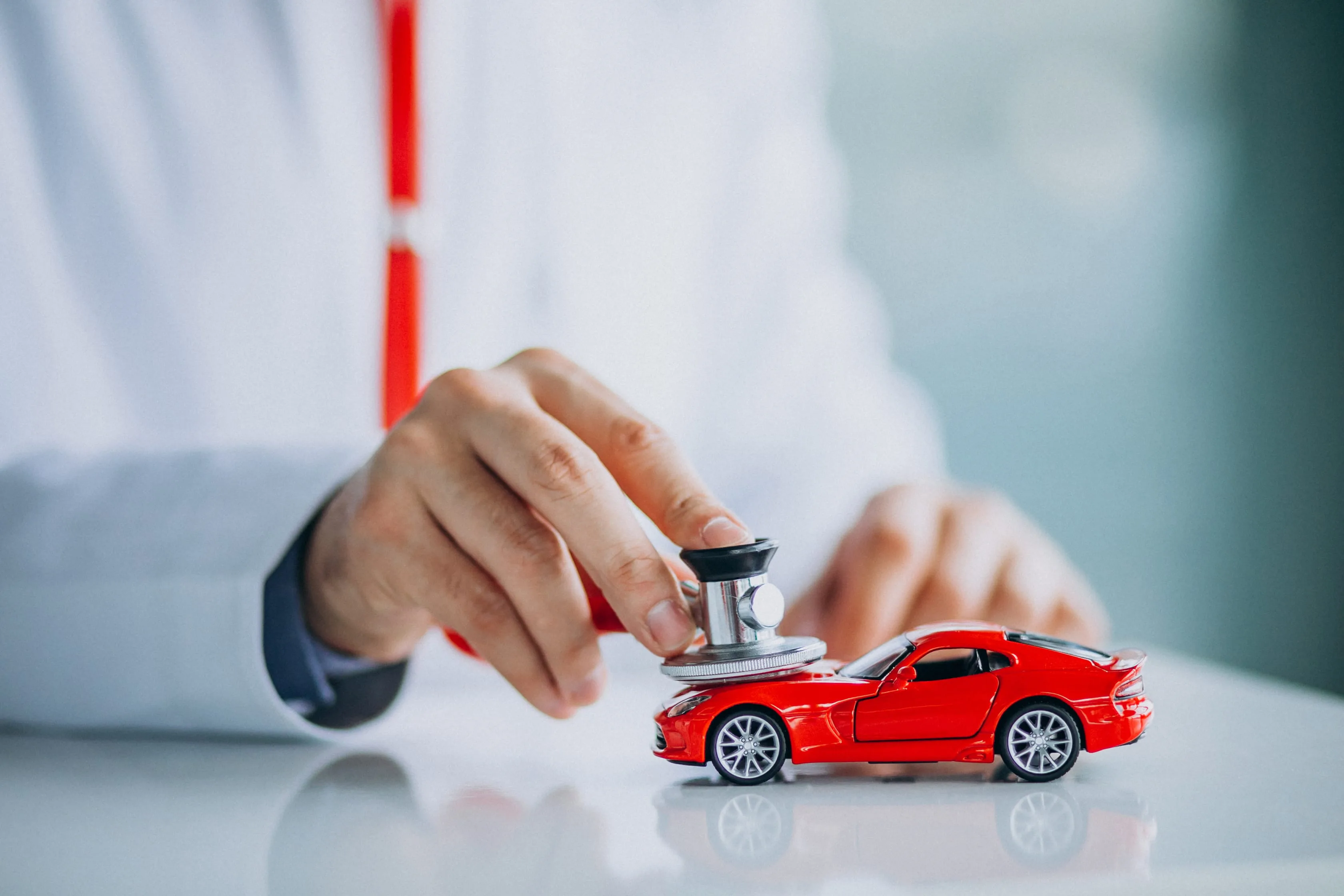Carro recebendo manutenção com profissional especializado, simbolizando um plano de saúde automotivo.