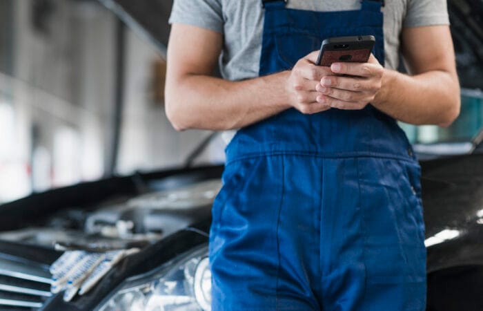 Atendimento de mecânico online via celular, representando o futuro da assistência veicular.